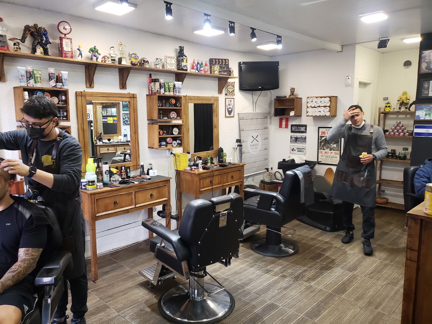 Barbeiro atendendo cliente dentro da Barber & Co., no Jardim Social